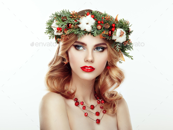 Portrait of beautiful young woman with Christmas wreath - Stock Photo - Images
