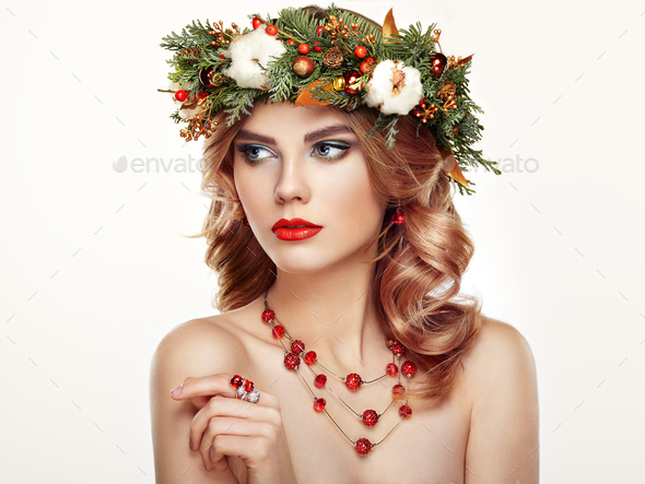 Portrait of beautiful young woman with Christmas wreath - Stock Photo - Images