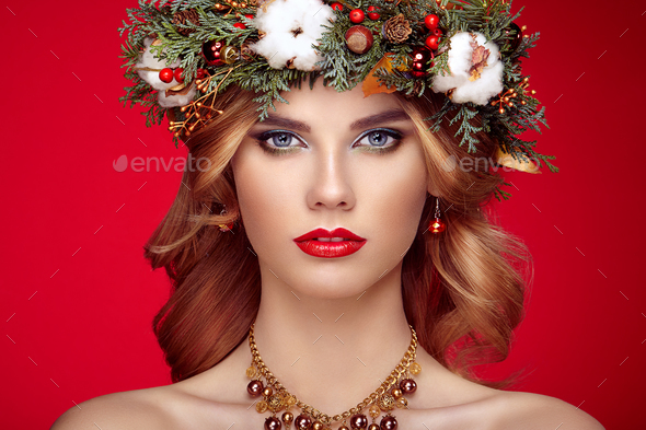 Portrait of beautiful young woman with Christmas wreath - Stock Photo - Images
