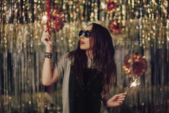 Attractive hipster girl holding sparklers in hands - Stock Photo - Images