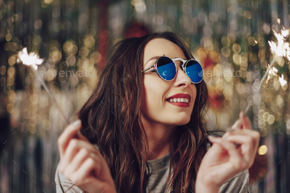 Beautiful girl holding sparklers in hands - Stock Photo - Images