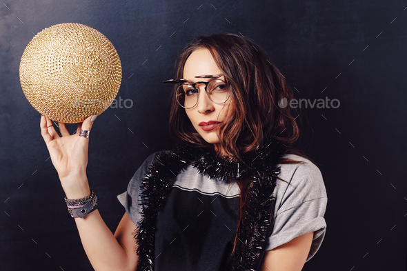 Portrait of seductive hipster girl holding a gold discoball - Stock Photo - Images