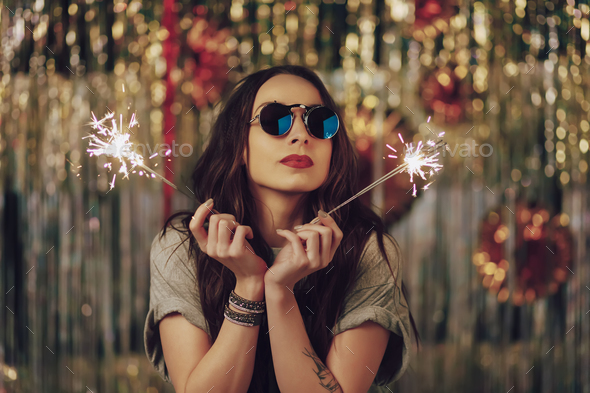 Attractive hipster girl holding sparklers in hands - Stock Photo - Images
