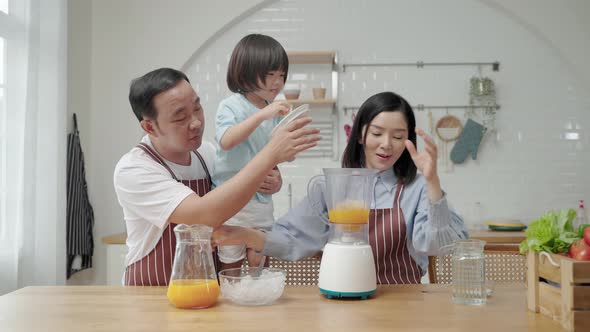 Asian family with father Mother and son helping to cook Making a smoothie in the kitchen