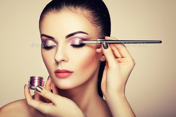 Makeup artist applies eye shadow - Stock Photo - Images
