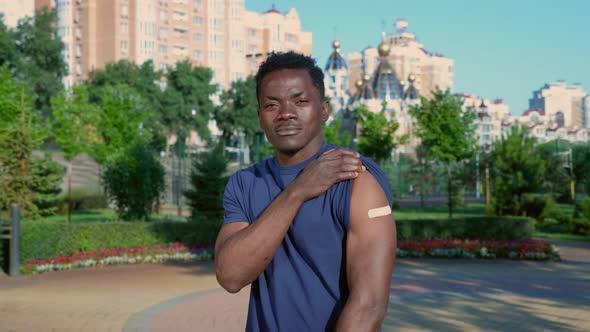 Afroamerican Man Patient Shows Medical Plaster Demonstrates Vaccine Injection alt