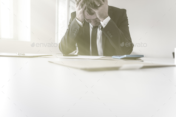 Despairing businessman with his head in his hands - Stock Photo - Images