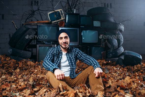 Stalker, mountain of old TVs on background - Stock Photo - Images