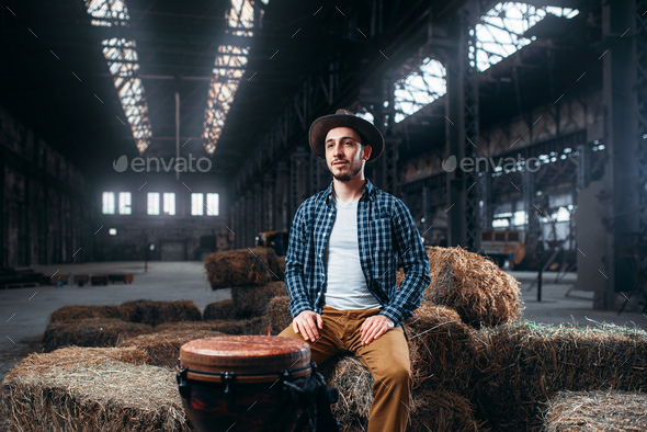 Young male drummer against african wooden drum - Stock Photo - Images
