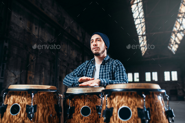 Male drummer plays on wooden drum - Stock Photo - Images
