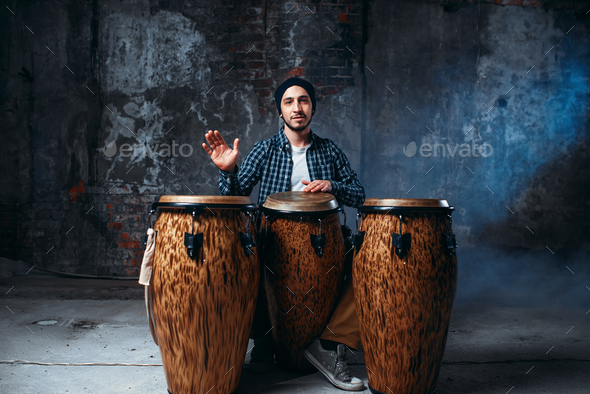 Drummer playing on wooden bongo drums, beat music