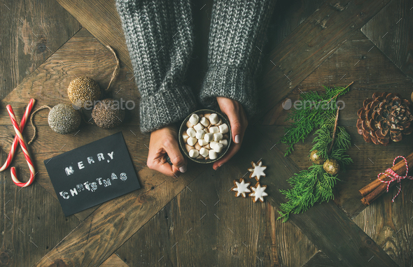 Flat-lay of greeting card, woman's hands in sweater holding mug - Stock Photo - Images