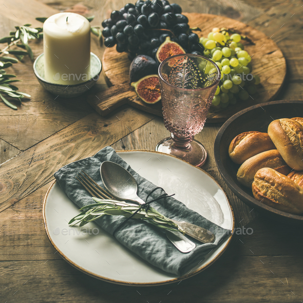 Plate with linen napkin, fork, spoon, glass, candle, fruits, bread - Stock Photo - Images