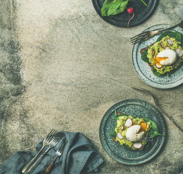 Healthy vegetarian wholegrain avocado toasts with poached egg, copy space - Stock Photo - Images