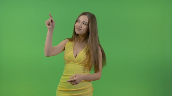 Beautiful Girl in a Yellow Dress, on a Green Screen. She Turns and Makes a Gesture with Her Hand.