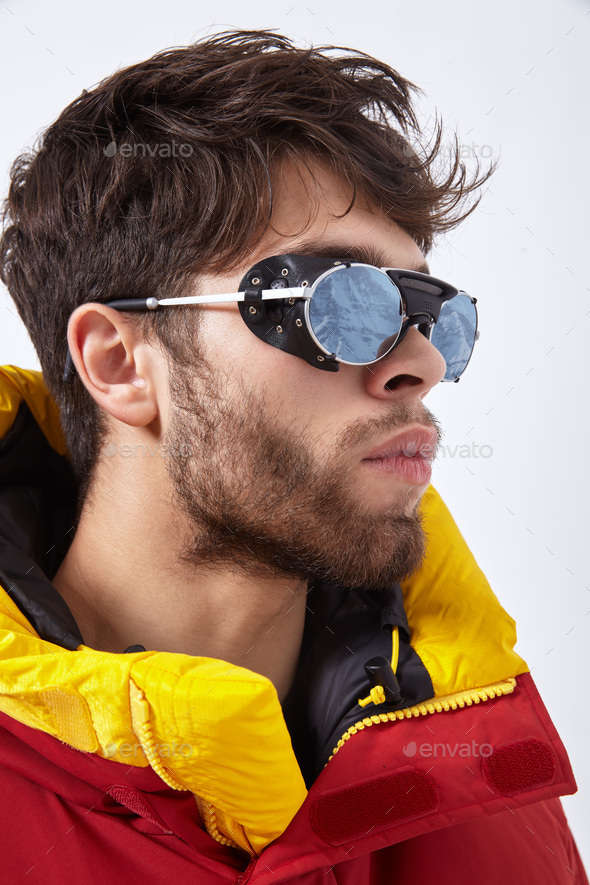 Portrait of mountaineer in winter clothes and ultraviolet protected sunglasses - Stock Photo - Images