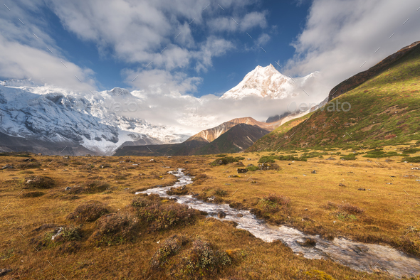 Mountains with snow covered peaks and small river - Stock Photo - Images