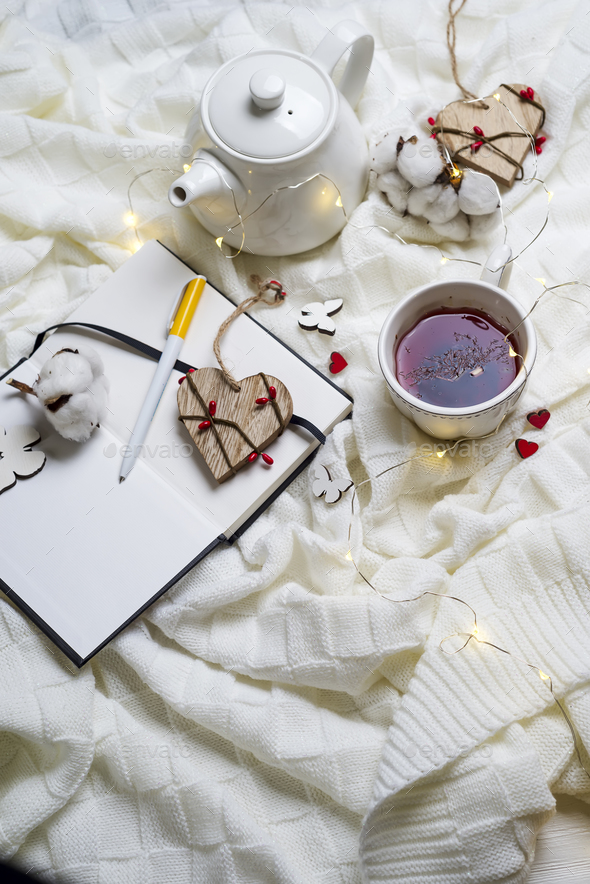 Warm knitted plaid,cup of hot tea and notebook - Stock Photo - Images