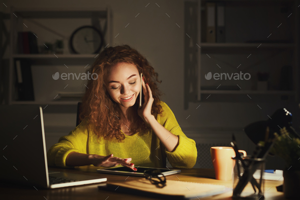 Smiling woman at work talking on phone - Stock Photo - Images