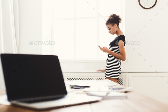 Businesswoman standing, using smartphone - Stock Photo - Images