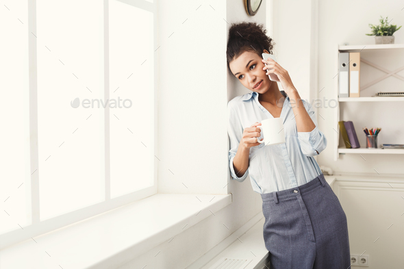 Business woman has phone talk near office window - Stock Photo - Images