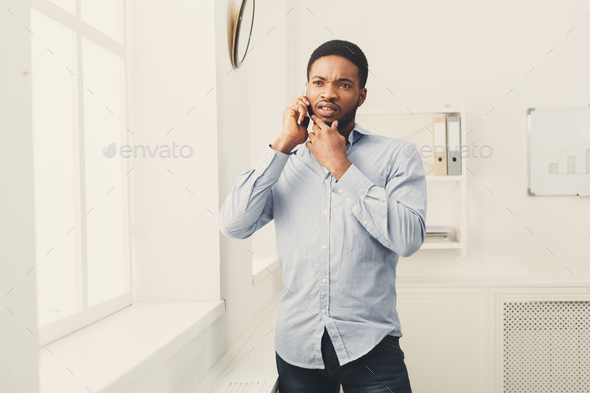 Businessman phone talking on phone near window - Stock Photo - Images