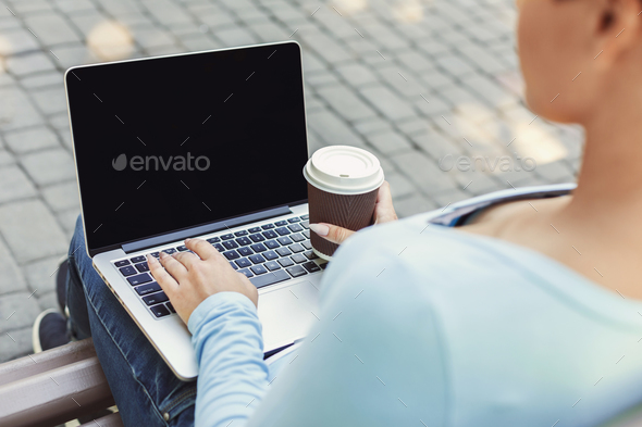 Female hands with laptop closeup,over shoulder shot outdoors - Stock Photo - Images