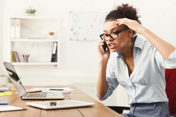 Business talk, angry woman talking on phone at office Stock Photo by Milkosx