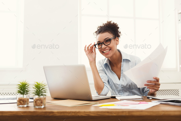 Happy business woman reading document at office desktop Stock Photo by Milkosx