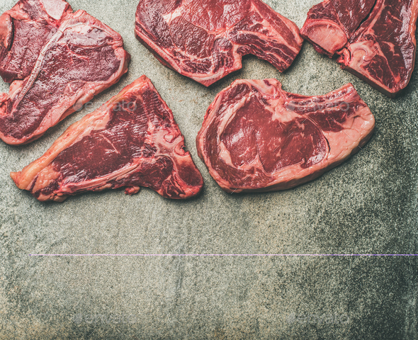 Porterhouse, t-bone and rib-eye steaks over grey background - Stock Photo - Images