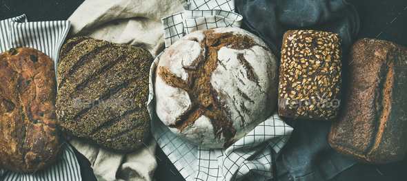 Flat-lay of Various bread selection loaves, black background - Stock Photo - Images