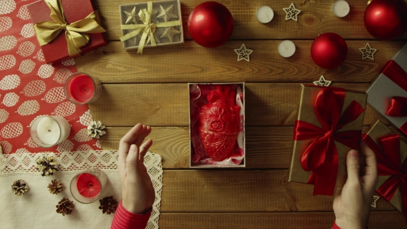 Man Opens Christmas Gift Box with Real Human Heart Made of Plastic Inside on Decorated Wooden Table