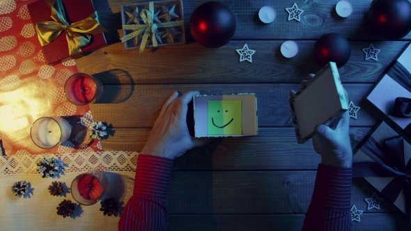 Top Down Shot of Man Opening New Year Gift Box with Sticky Note with Smile Inside