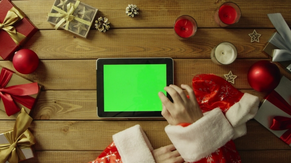 Santa Uses Tablet Pc with Green Screen By Christmas Decorated Table, Top Down Shot