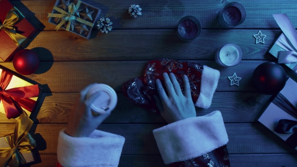 Santa Claus Drinks Tea By Christmas Wooden Table, Top Down Shot