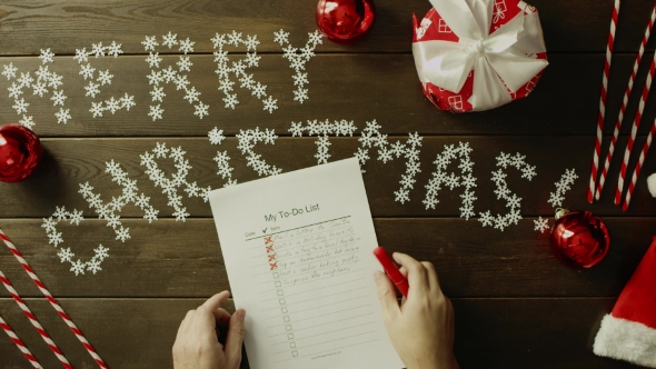 Man Fills Up His To-do List Before Christmas, Top Down Shot