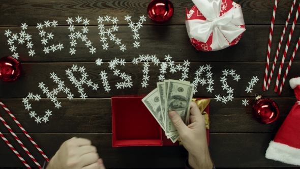 Adult Man Opens New Year Gift with Cash Money Inside, Top Down Shot