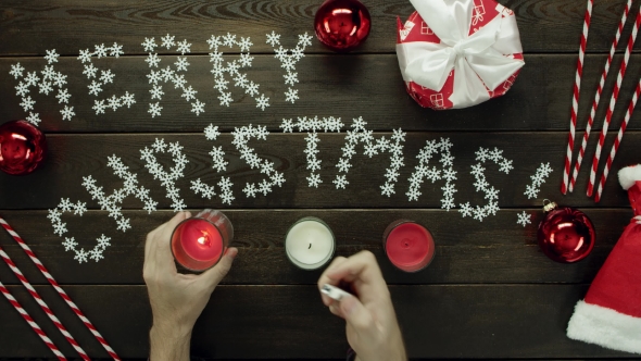 Man Lights Xmas Candles By Decorated Table, Top Down Shot