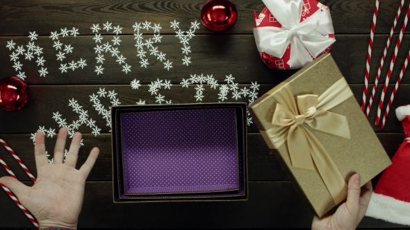 Man Opens Empty Xmas Present By Holiday Table, Top Down Shot