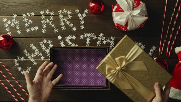 Man Opens Empty Xmas Present Box By Wooden Holiday Table, Top Down Shot