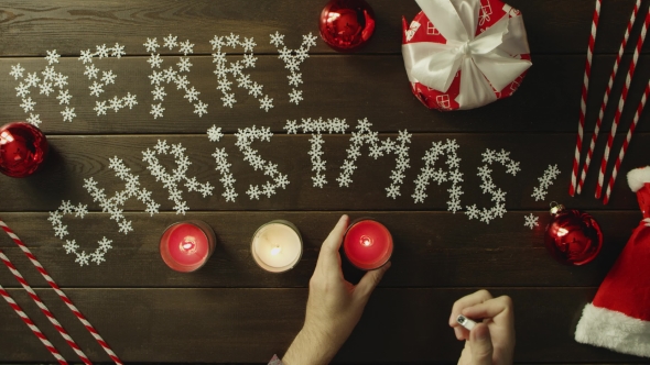 Man Lights Christmas Candles By Decorated Table, Top Down Shot