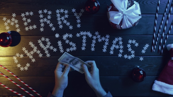 Adult Man Counts Cash Money By New Year Decorated Table, Top Down Shot