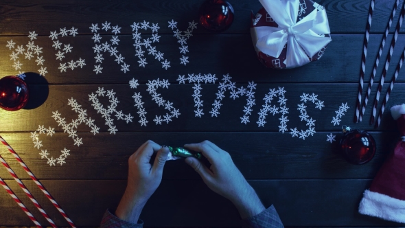 Man Unwraps Candy, Eats It and Throws Wrapper on New Year Decorated Table, Top Down Shot