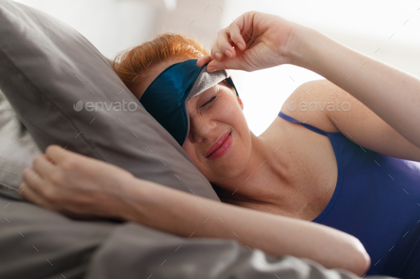 Woman In Bed With Sleep Mask On Eyes Waking Up