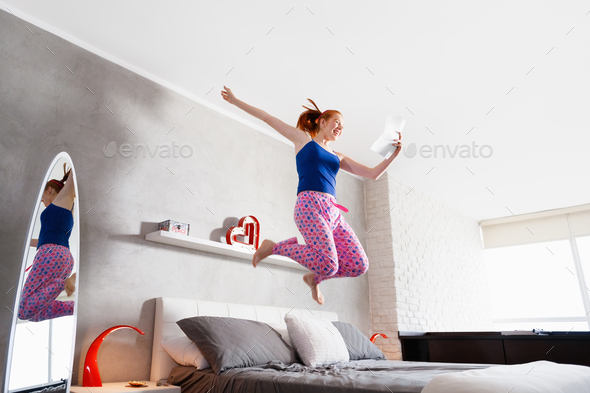 Good News For Happy Young Woman Girl Jumping On Bed - Stock Photo - Images