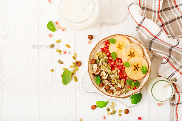 Tasty and healthy oatmeal porridge with apples, pomegranate and nuts - Stock Photo - Images
