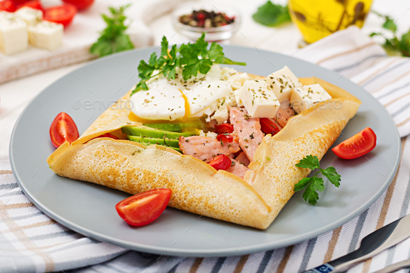 Pancakes with egg poached, feta cheese, fried ham, avocado and tomatoes - Stock Photo - Images