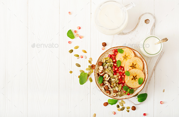 Tasty and healthy oatmeal porridge with apples, pomegranate and nuts. - Stock Photo - Images
