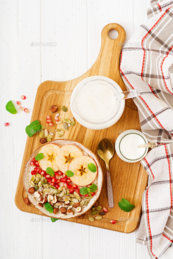Tasty and healthy oatmeal porridge with apples, pomegranate and nuts. - Stock Photo - Images