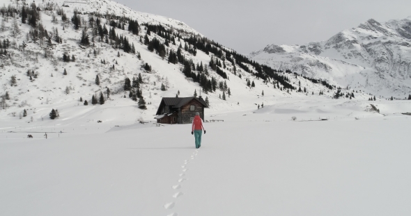 Woman Is Walking Towards Ski Lodge alt